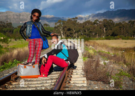 African ragazzo e ragazza in attesa del treno sulle piste Foto Stock