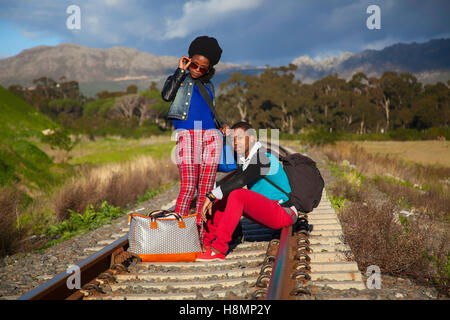 African ragazzo e ragazza in attesa del treno sulle piste Foto Stock