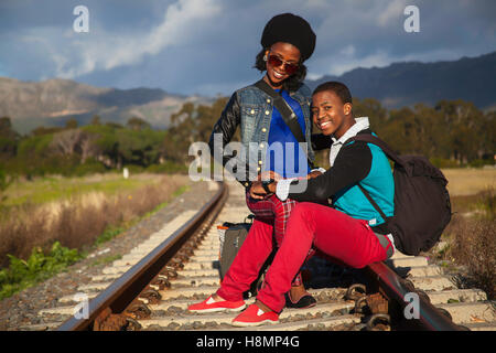 African ragazzo e ragazza in attesa del treno sulle piste Foto Stock