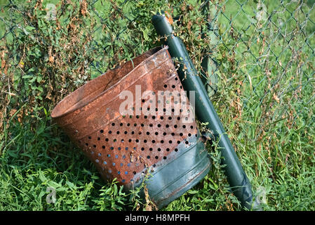 Primo piano di una rotta e rusty nel cestino nel parco Foto Stock