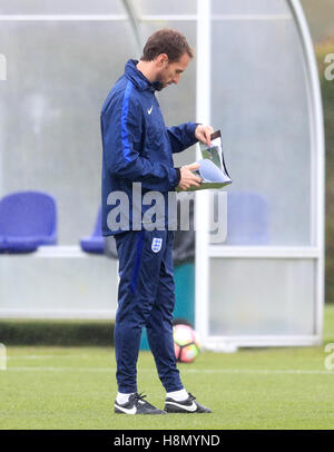 Inghilterra responsabile ad interim Gareth Southgate guarda attraverso la sua cartella durante una sessione di formazione a Tottenham Hotspur Training Centre di Londra. Foto Stock