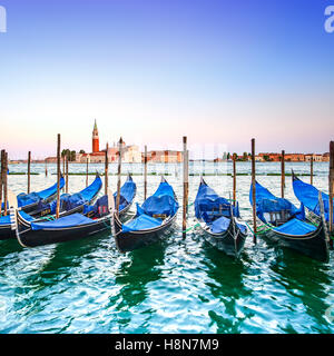 Venezia tramonto, gondole o gondole su un cielo blu e la chiesa di San Giorgio Maggiore punto di riferimento sullo sfondo. L'Italia, l'Europa. Foto Stock