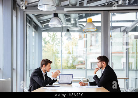 Concentrato di due giovani imprenditori lavora insieme a un incontro di affari in ufficio Foto Stock