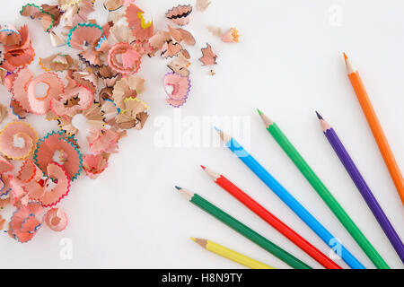 Matite multicolori e trucioli su sfondo bianco con spazio di copia Foto Stock