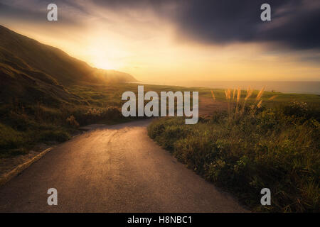 Strada fino alla spiaggia Azkorri al tramonto Foto Stock