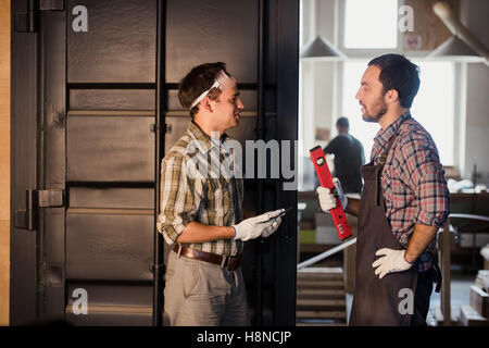 Professione, tecnologia e concetto di persone - due operai con tablet pc computer in officina Foto Stock