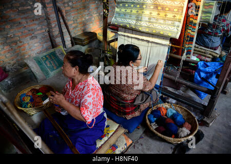 NEPAL Kathmandu, Lalitpur, campo profughi tibetano Jawalakhel, fabbrica di tappeti JHC Jawalakhel Handicraft Center, donne rifugiate tibetane annodano tappeti a telaio per generazione di reddito Foto Stock