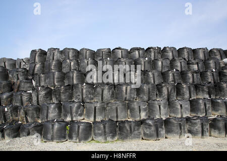 Pila di sacchi di sabbia big bag, sito in costruzione contro un cielo blu Foto Stock