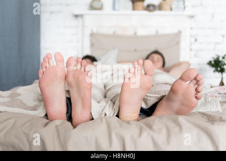 In prossimità delle coppie gay piedi giacente a letto Foto Stock