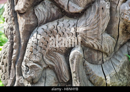 Decorazione: su un tronco di albero scolpito la figura di pesce. Foto Stock