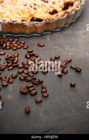 I chicchi di caffè. Torta fatta in casa. Caffè in grani sparsi sul bancone della cucina Foto Stock