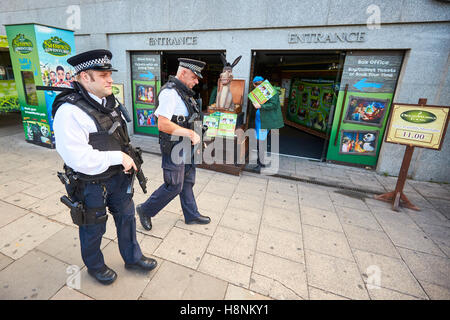Armati di pattuglia di polizia al di fuori di Shrek avventura attrazione turistica a County Hall a Londra il South Bank Foto Stock