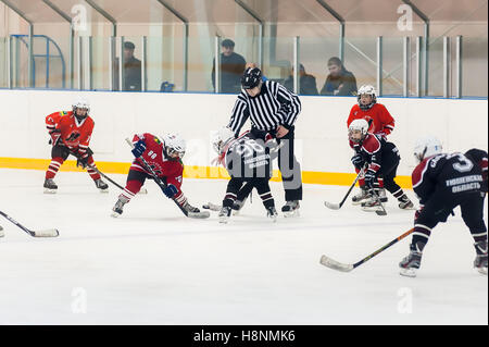 Puck giocando tra giocatori di hockey su ghiaccio squadre Foto Stock