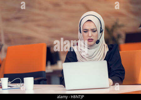 Giovani arabi business donna indossa hijab,lavorando nel suo ufficio di avvio. Foto Stock