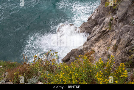 Vista dalla parte superiore delle onde che si infrangono al di sotto. Costiera Amalfitana, Italia Foto Stock