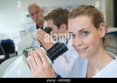Team di scienziati in un laboratorio lavora con microscopi Foto Stock