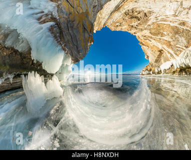 Grotta di ghiaccio nella roccia sulla isola di Olkhon sul lago Baikal ricoperto di ghiaccio ampio angolo di panorama. Foto Stock