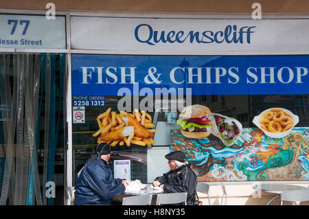 Coppia di anziani di mangiare al di fuori di una vecchia pesce e patatine shop in Queenscliff, Victoria Foto Stock
