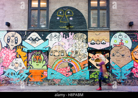 Donna cammina passato street art di Oslo. Foto Stock