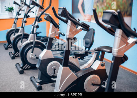 Aerobica spinning cyclette palestra con molti in una riga Foto Stock