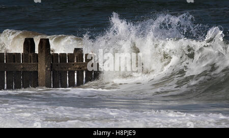 Onde che si infrangono sulla revetments difese di mare sulla Costa North Norfolk Foto Stock
