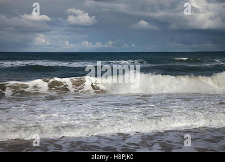 Le onde che si infrangono sulla costa di Norfolk Foto Stock