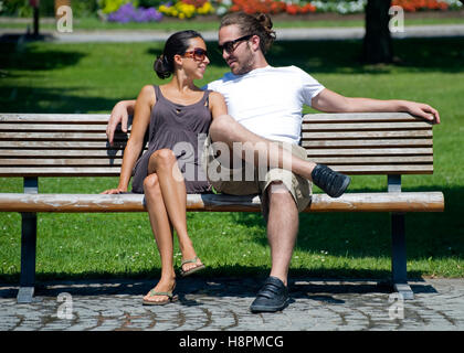 Amore giovane su una panchina nel parco Foto Stock