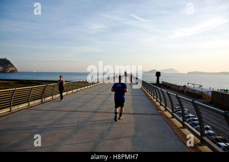 Jogging sulla North Wharf, ex Italsider, ex acciaierie area industriale, Via Coroglio, quartiere di Bagnoli, Napoli, Campania Foto Stock