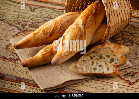 Baguette in un cesto su sfondo di legno Foto Stock