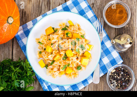 Farfalle con fette di zucca e prezzemolo Foto Stock