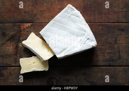 Pezzo di francese Formaggio Brie sul vecchio sfondo di legno Foto Stock