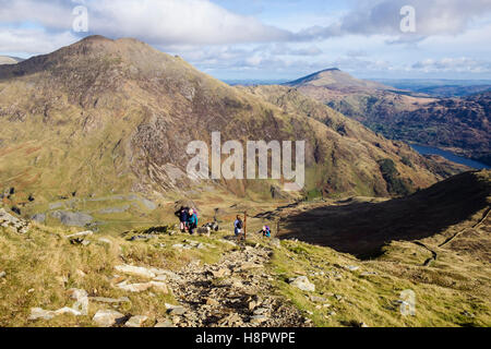 Gli escursionisti escursionismo Alto Yr Aran sopra Cwm Llan con Y Lliwedd al di là delle montagne del Parco Nazionale di Snowdonia. Gwynedd, Wales, Regno Unito Foto Stock