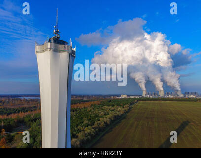 Flutti di vapore aumento da torri di raffreddamento della lignite power plant Jaenschwalde della LEAG (Lausitz Energy Mining AG), l ex Vattenfall AG, vicino a Cottbus (Germania), 9 novembre 2016. In primo piano la torre di avvistamento di quasi 50 metri nel parco dei divertimenti "Teichland' può essere visto. Esso è costituito da una pista di slittino estivo e il labirinto, tra le altre cose. La struttura ricreativa vanta di 18 ettari di terreno è situato sulla collina di Baerenbruecker. Da un 50 metri di alta torre di avvistamento i visitatori possono godere di una meravigliosa vista del paesaggio circostante. La fotografia è stata scattata con un Foto Stock