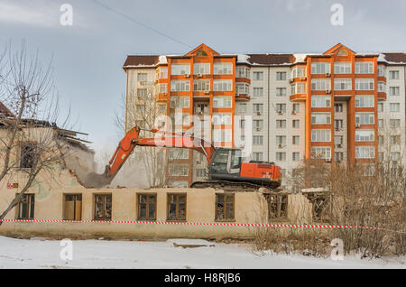 Digger demolizione di case per la ricostruzione Foto Stock