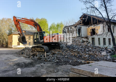 Digger demolizione di case per la ricostruzione Foto Stock