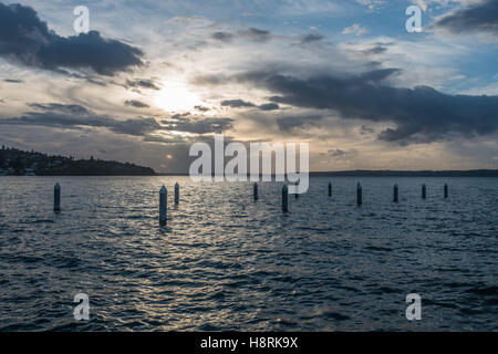 Il sole tramonta dietro le nuvole a Redondo Beach, Washington. Foto Stock