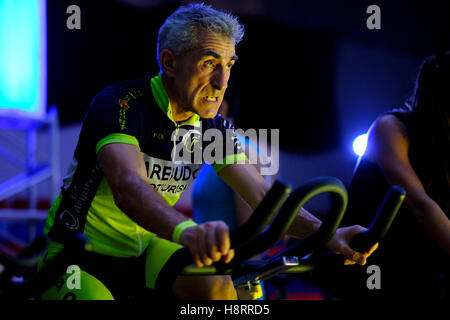 Uomo di equitazione bicicletta stazionaria durante una lezione di spinning presso la palestra Foto Stock