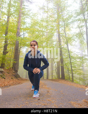 Energico giovane donna fare esercizi all'aperto nel parco per mantenere i loro corpi in forma Foto Stock