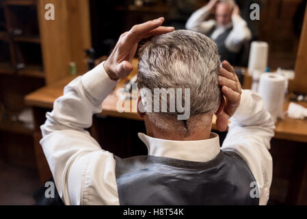 Vista posteriore del senior styling uomo i suoi capelli Foto Stock