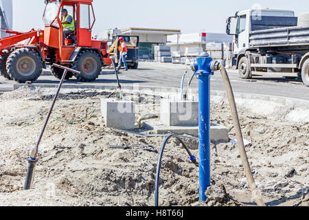 Il tubo flessibile di acqua è attaccato al posto di recente incendio sul sito in costruzione. Foto Stock