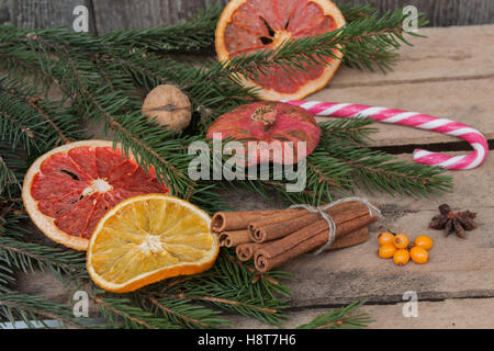 Composizione di natale. Rami di abete rosso, candy cane, secchi Arance, Pompelmi, cannella, giocattoli di Natale, noci, anice stellato, p Foto Stock