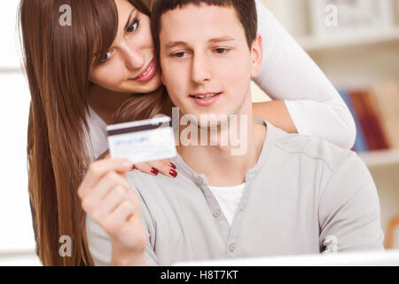 Ritratto di una coppia felice con il laptop per le transazioni bancarie. Foto Stock