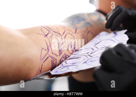 Disegno Tatoo sulla sua spalla. Tatuaggio, tattoo artist fa il tatuaggio su la mano dell'uomo. Foto Stock