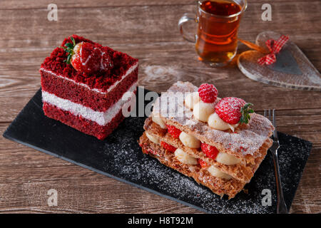 Mille"feuille dessert fetta dolce torta rossa del velluto con glassa bianca è guarnito con fragole Foto Stock