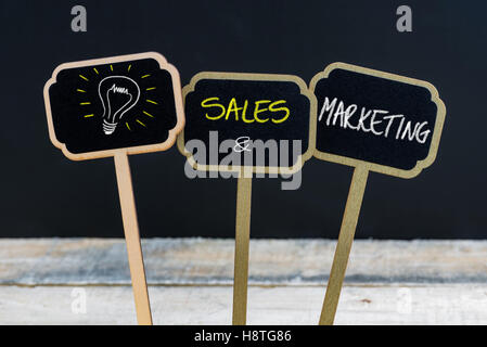 Messaggio di concetto di vendite e marketing e lampadina della luce come simbolo per idea scritto con un gessetto su legno mini etichette di Blackboard Foto Stock