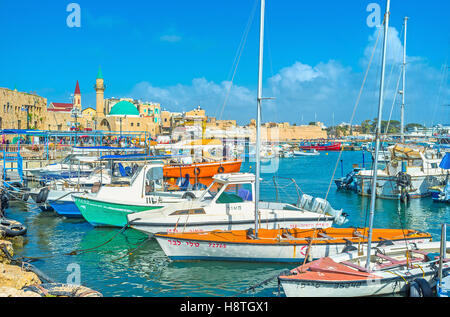 Le barche nel porto medievale di Akko, denominato HaDayagim, con la cupola verde Sinan Basha moschea di mare Foto Stock