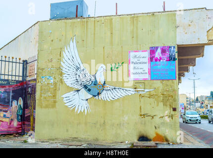 Il murale della colomba della pace vestito in un armatura per il corpo con l'obiettivo sul suo cuore dipinto sul muro della casa Foto Stock