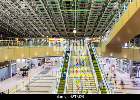 Giappone, Stazione di Osaka City, Porta Nord edificio. Interno. Scalone a Taki-no-hiroba Plaza, l'atrio principale. Notte tempo. Persone. HDR Foto Stock