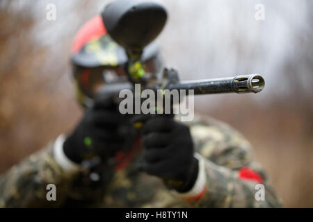 Paintball giocatore indossa la maschera protettiva e la pistola di puntamento Foto Stock