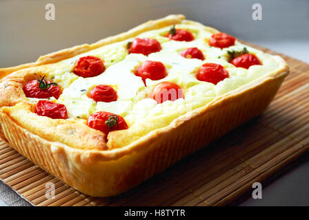 Gustosa Torta al forno con ripieno di ricotta e pomodori ciliegini. Foto Stock
